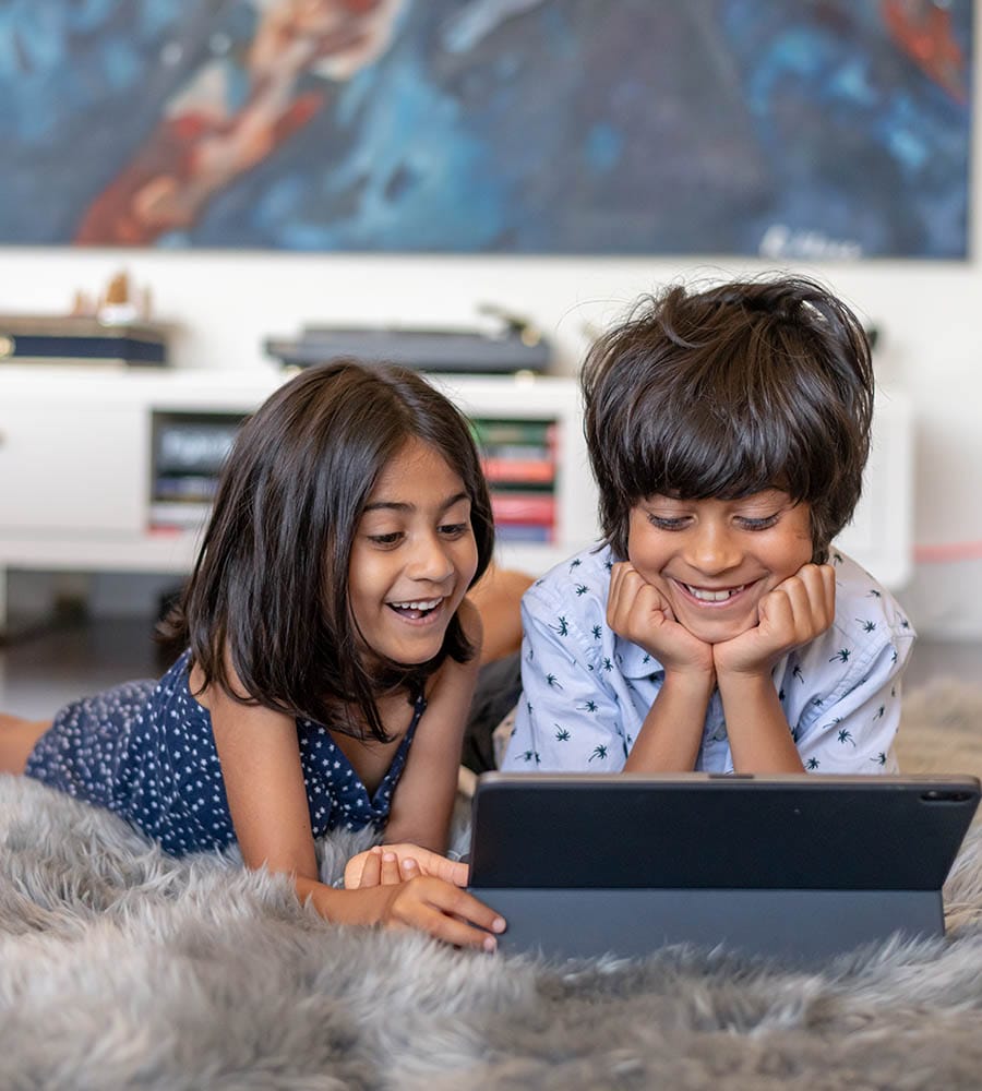 Elementary age siblings of Indian descent having video virtual playdate with friends