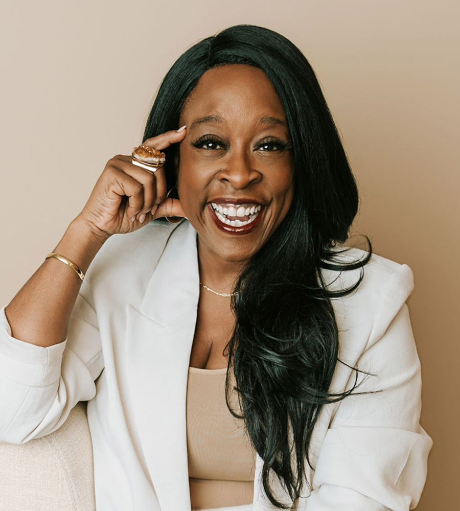 Headshot of Cheldin Barlatt Rumer smiling warmly, wearing a white business suit