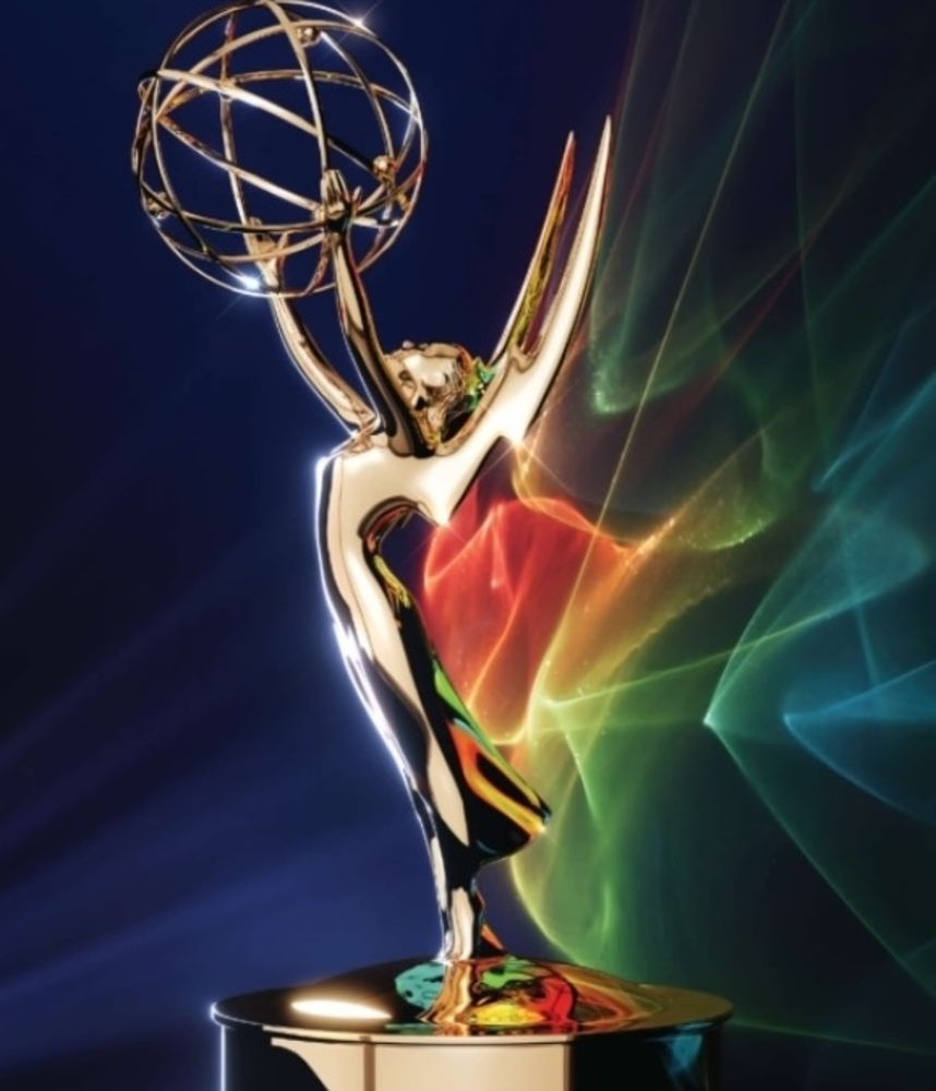Emmy Award statuette against a colorful abstract background